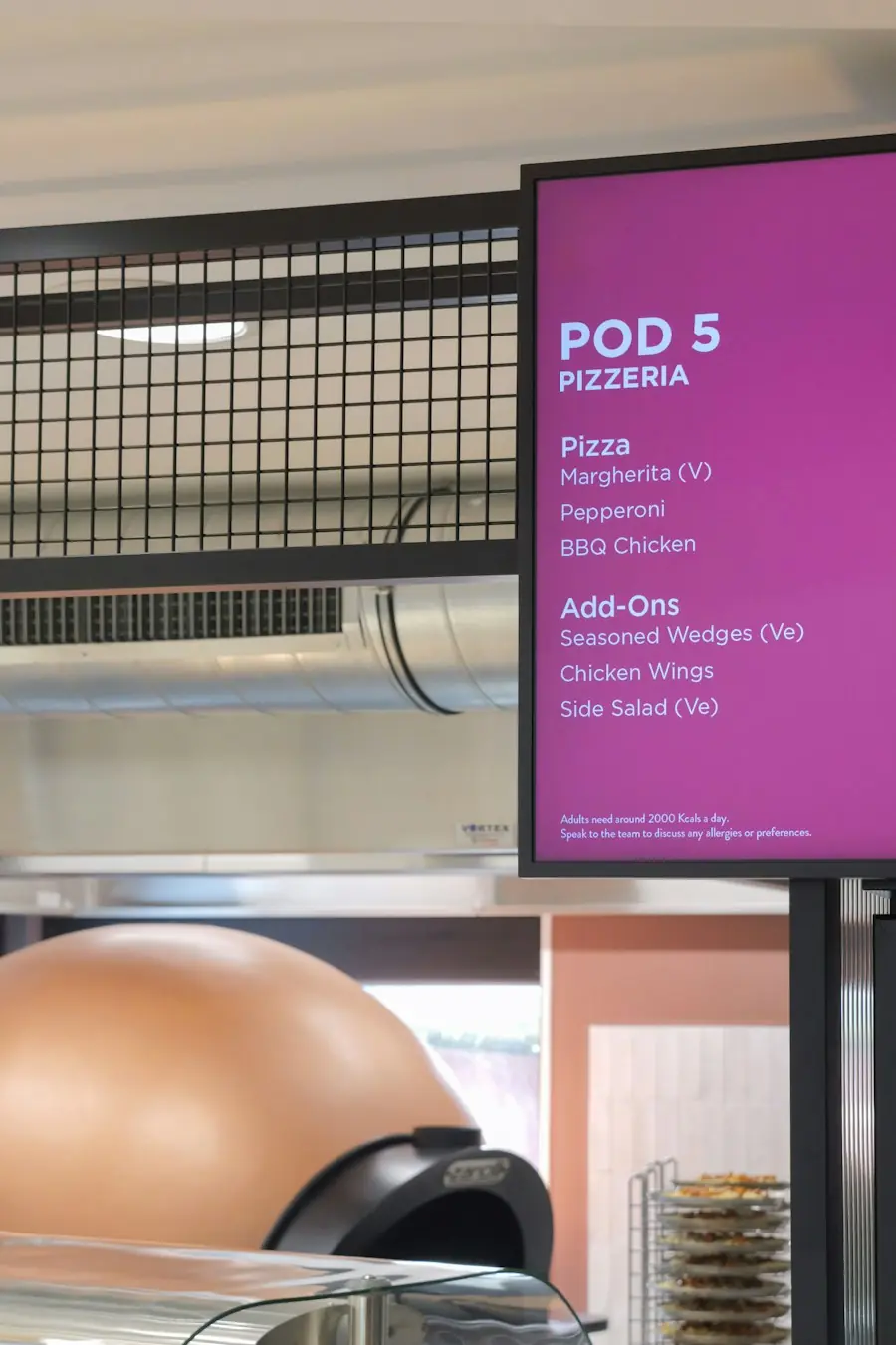Digital menu board glowing violet above a pizza oven