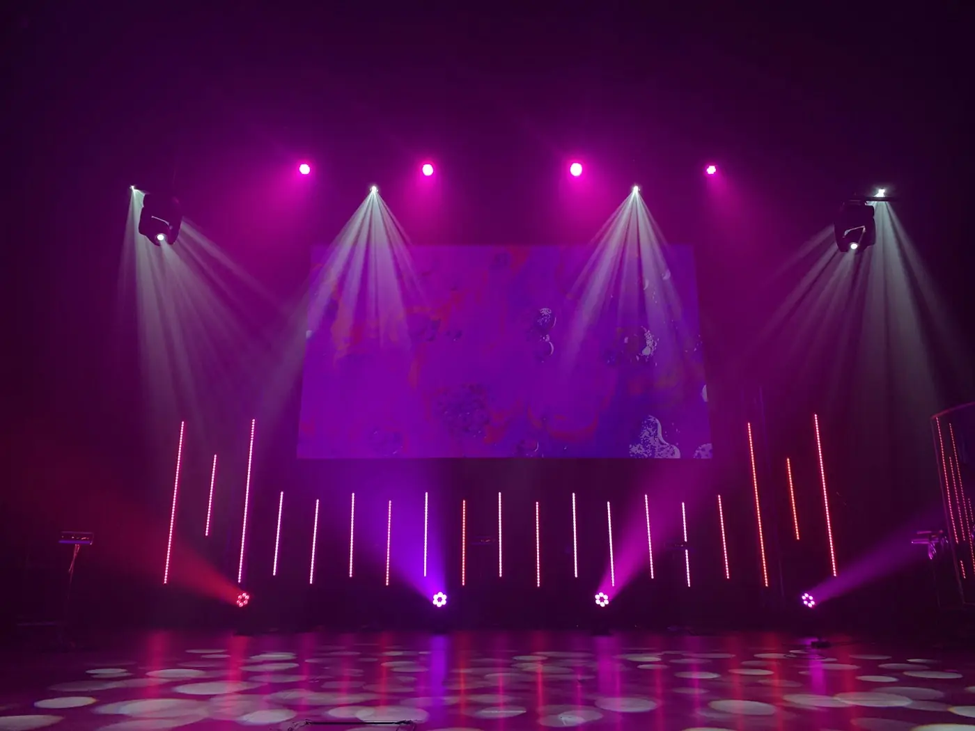 Event venue stage lit in violet with an LED backdrop